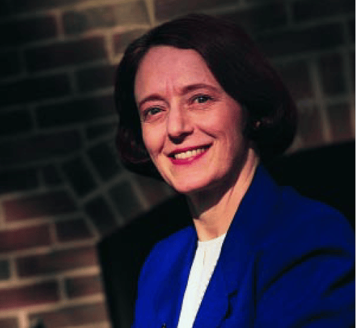 Portrait of professor Olivia Mitchell wearing a blue formal jacket and a white shirt underneath.