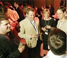 Alumni gather at an event, talking in a circle.