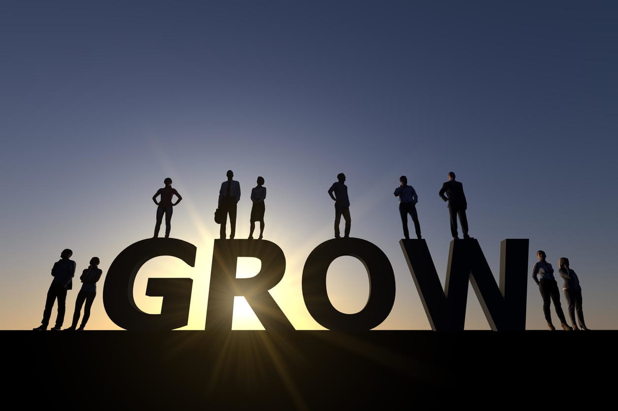 Conceptual image of a business team in silhouette standing on the word 