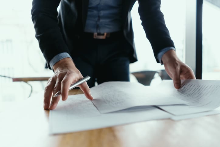 Businessman signing documents in office.