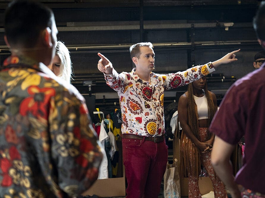 A man in a floral shirt directs others.