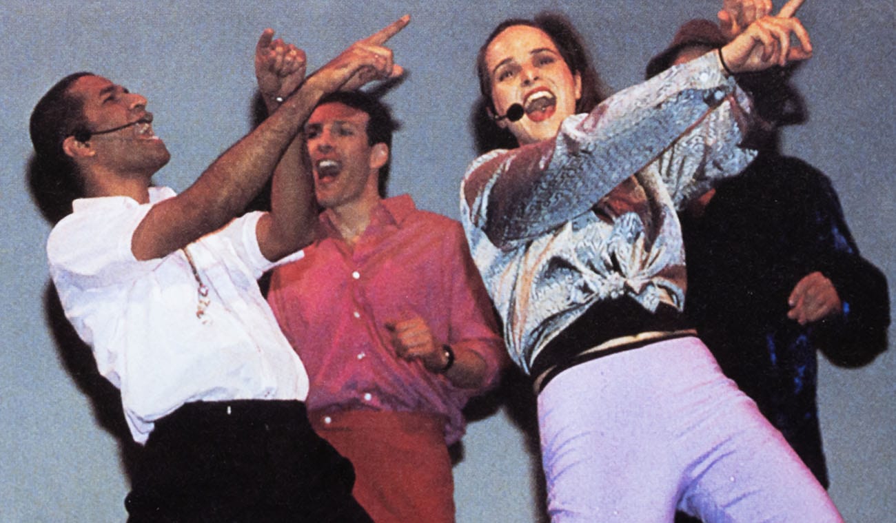 Four members of the Follies dance on stage and sing in a past performance.