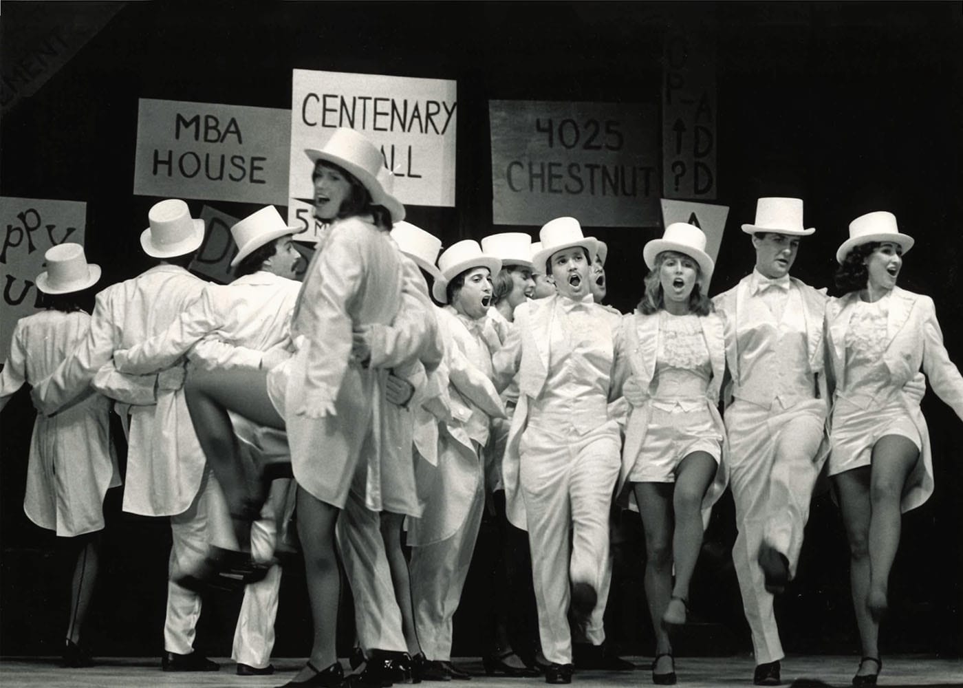 Follies performers dressed in white suit, skirts, and hats.