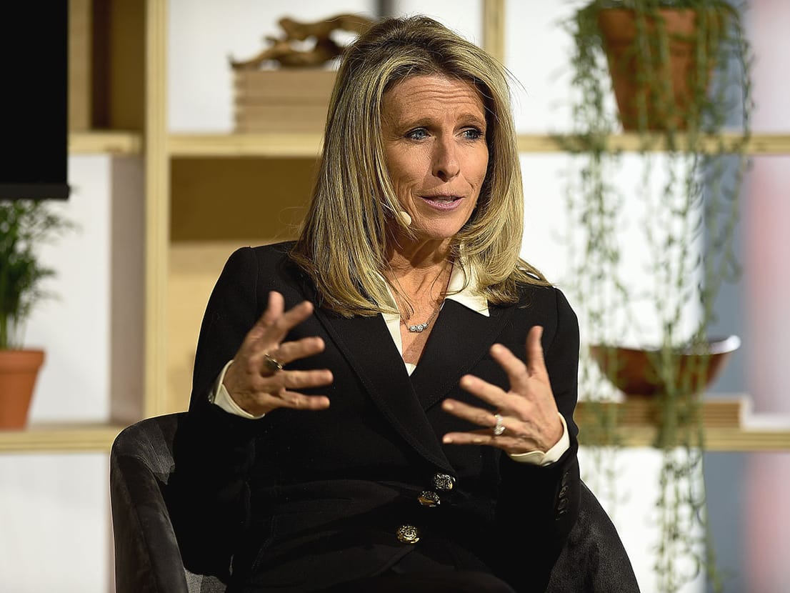 FanDuel CEO Amy Howe seated and gesturing with her hands while speaking on a stage.
