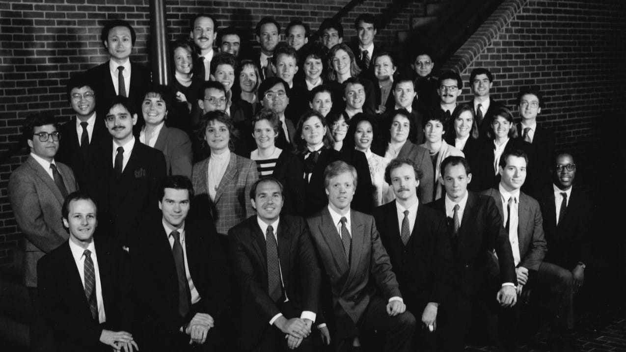 Forty-four Lauder students pose together on a staircase in rows and in formal attire in a black and white photo from the 1980s.