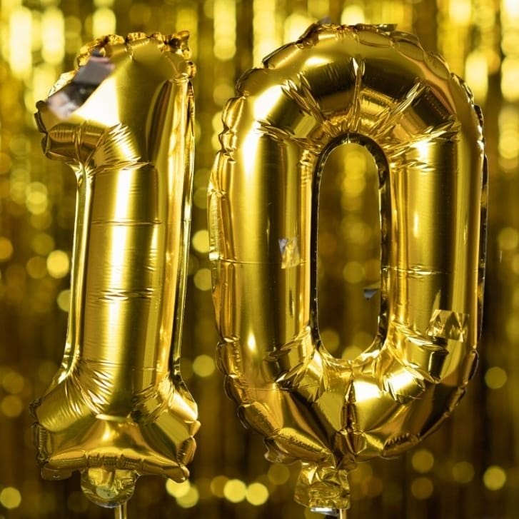 Gold celebratory balloons that together make the number 10.