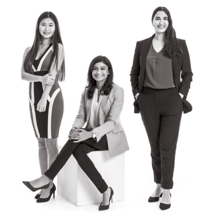Three Wharton women pose together for a photo in formal business attire.