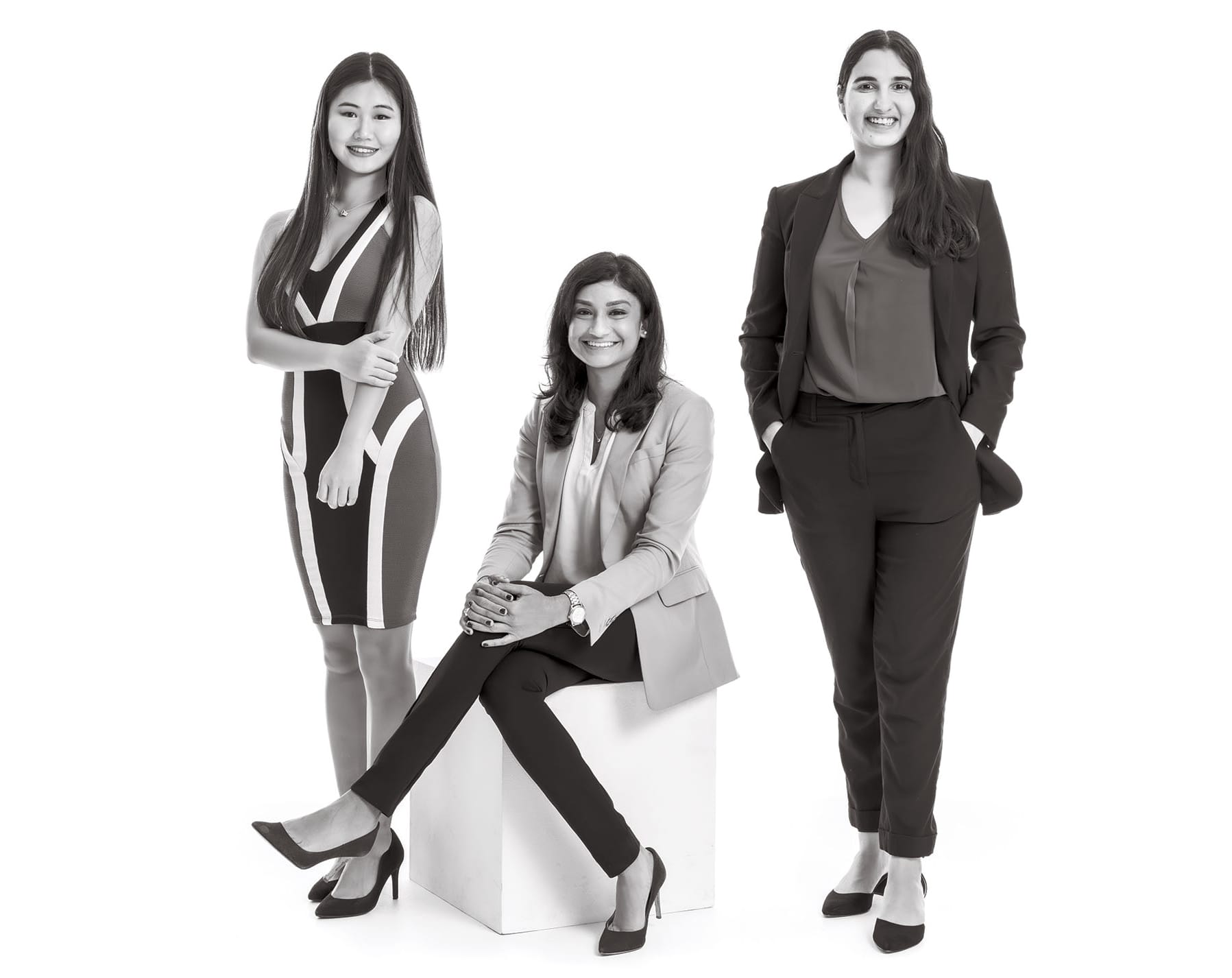Three Wharton women pose together for a photo in formal business attire.