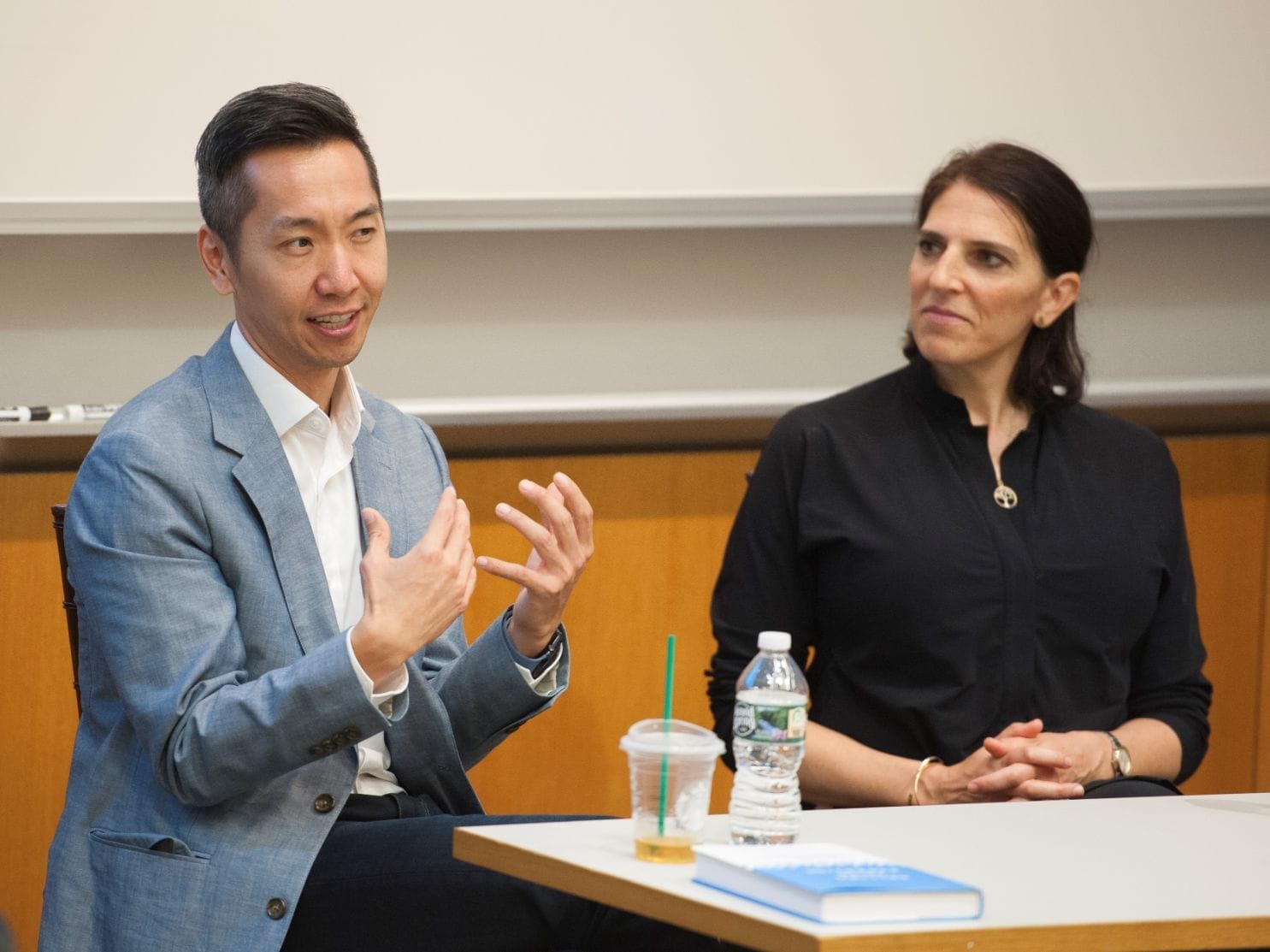 Alumni Robert Chen and Rachel Pacheco speak at the front of a classroom about their new books.