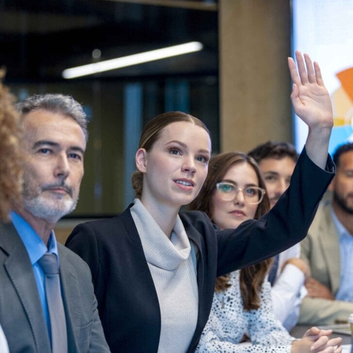 Woman raising her hand in a meeting