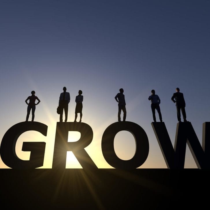 Conceptual image of a business team in silhouette standing on the word 
