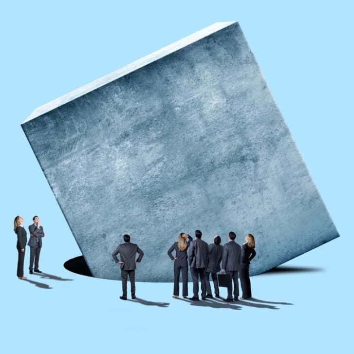 Illustration of businesspeople staring in confusion at a cube trying to fit in a round hole.