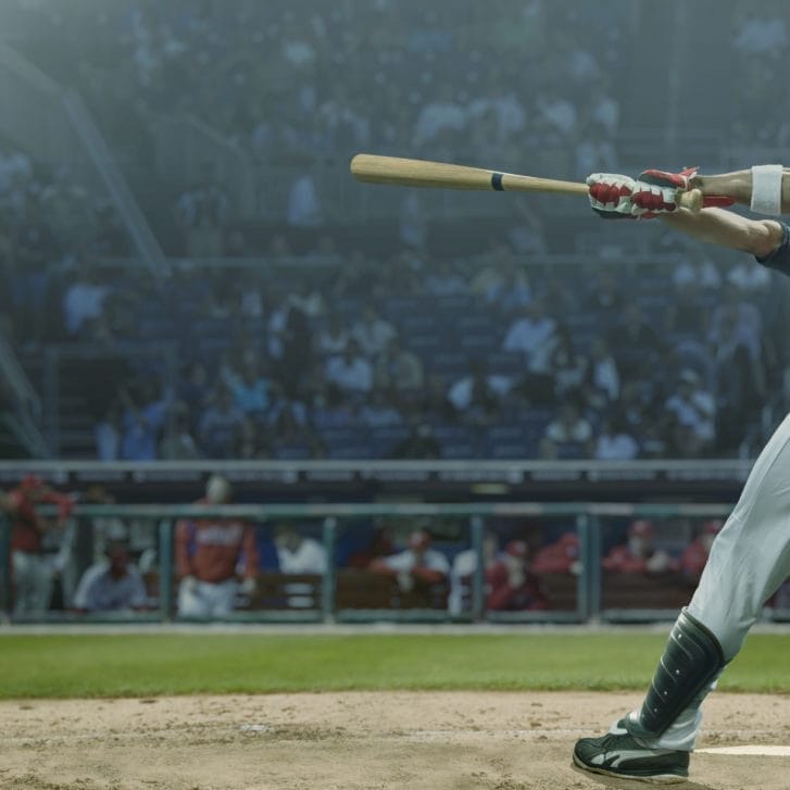 A baseball player hitting a baseball with a bat.
