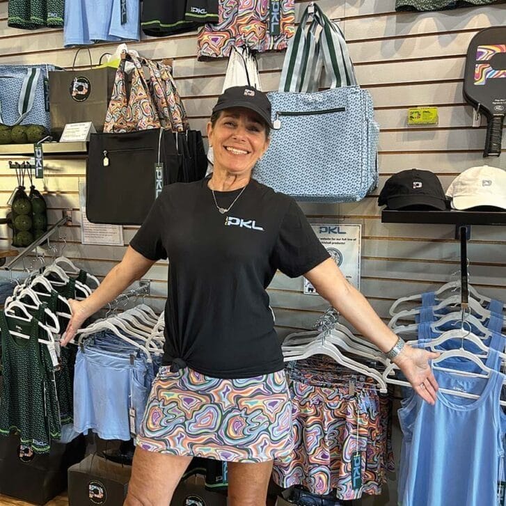 Heidi Block WG95 standing in front of pickleball apparel.