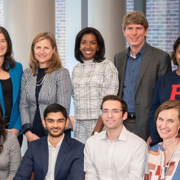 Dean Erika James standing amid eight Penn colleagues, including Penn president Liz Magill, for a posed photo in business attire.