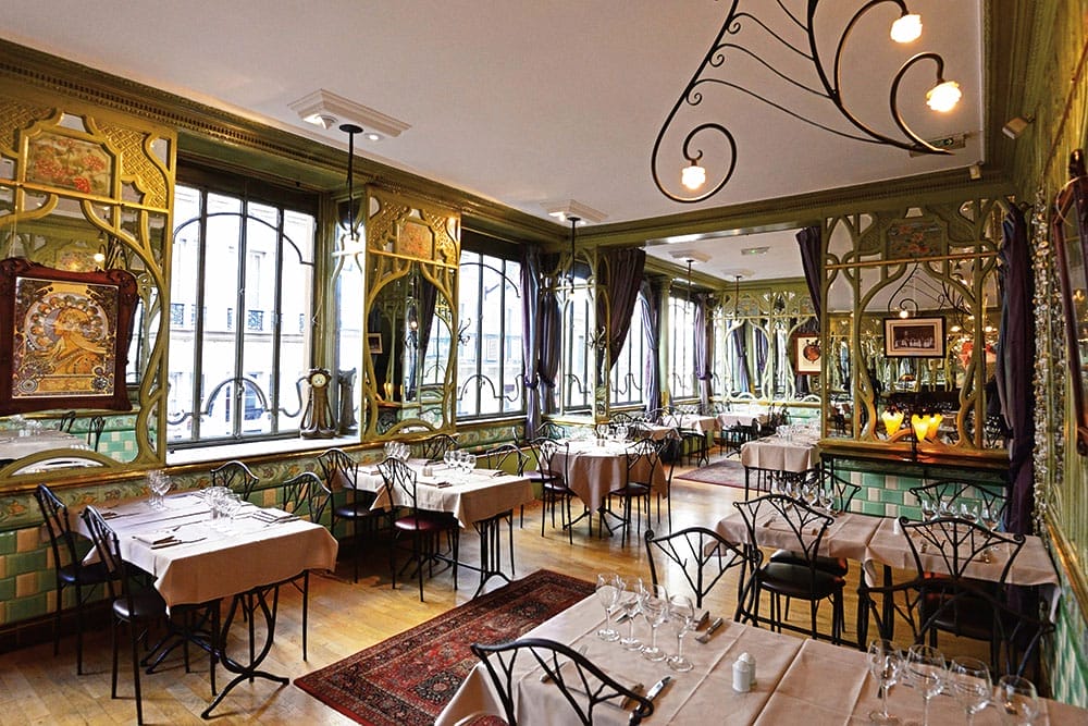 Seating at the Bouillon Racine, including ornate decorations and art on the walls.