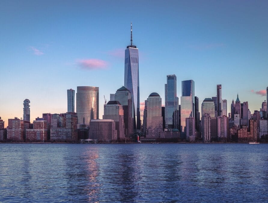 Skyline of New York City with One World Trade Center towering over other buildings.