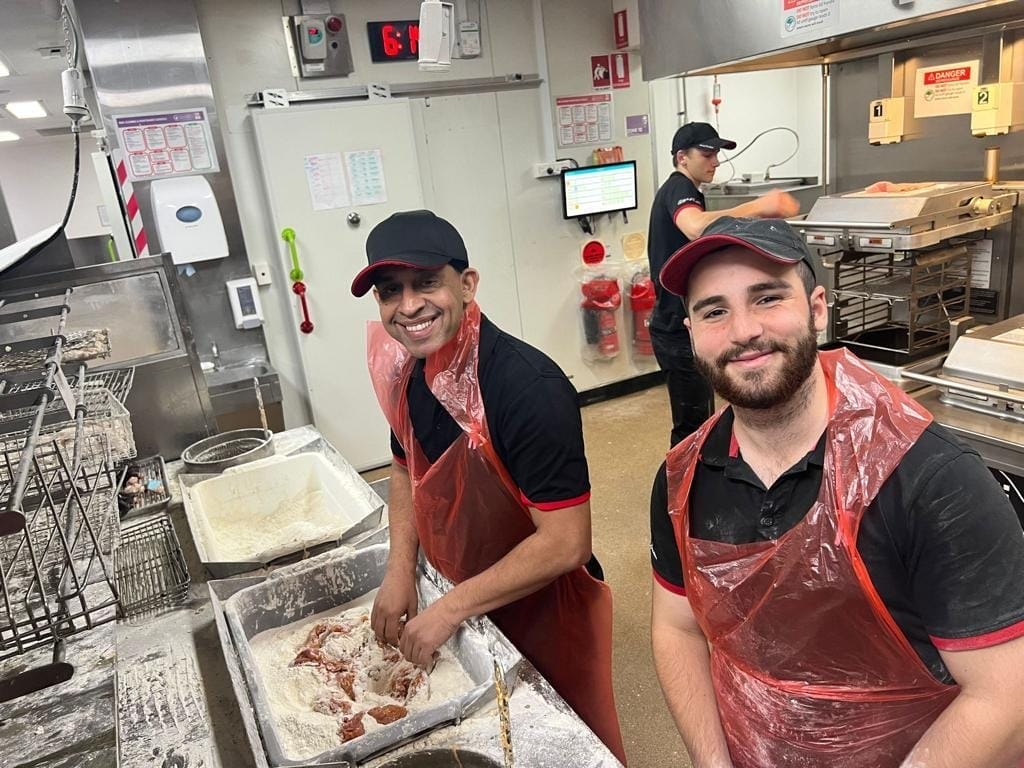 Nitin Chaturvedi working in the kitchen of a KFC alongside a colleague.