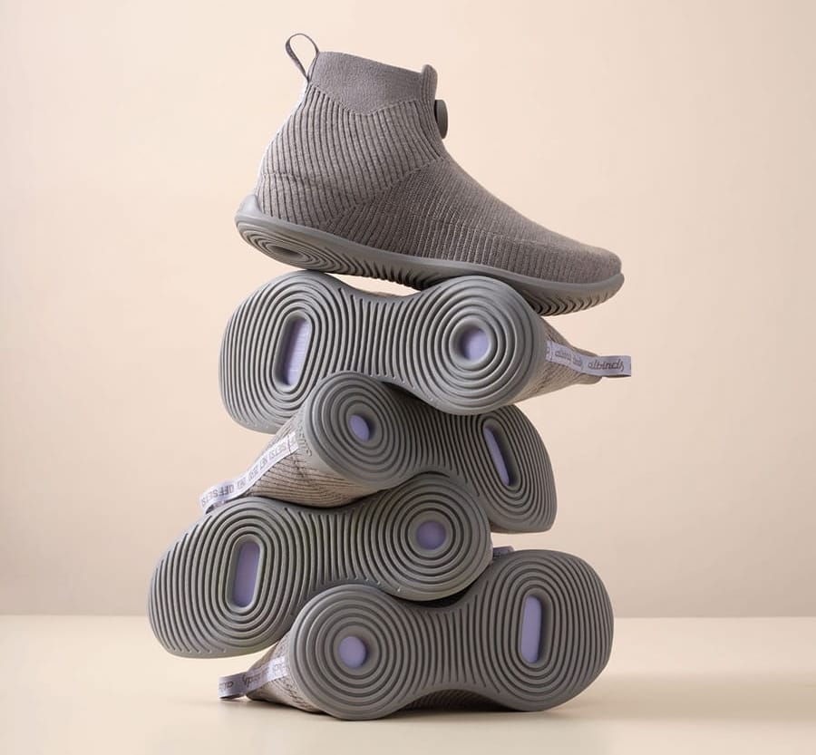 Five pairs of white high-top shoes stacked on top of each other in a column.