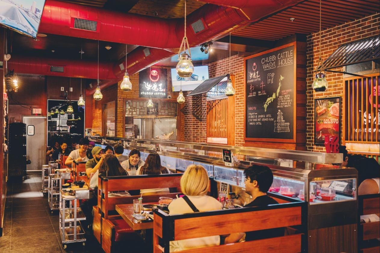 Restaurant goers seated in hot pot booths.