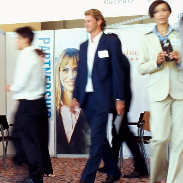 Businesspeople walking around an exhibition.