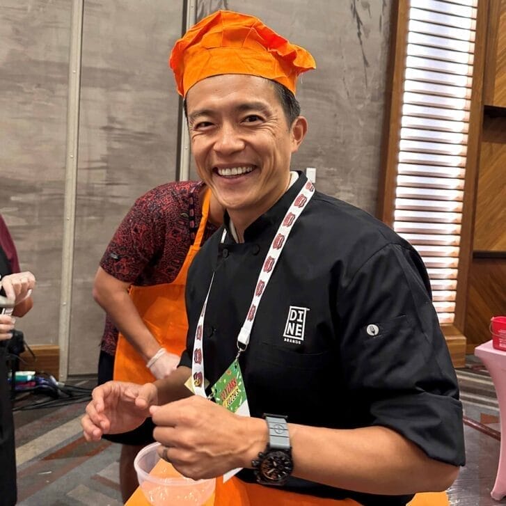 Vance Chang in a chef hat and Dine Brands Global uniform.
