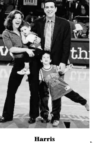 Pam Harris, WG’87, his wife, and two kids stand at center in a basketball court
