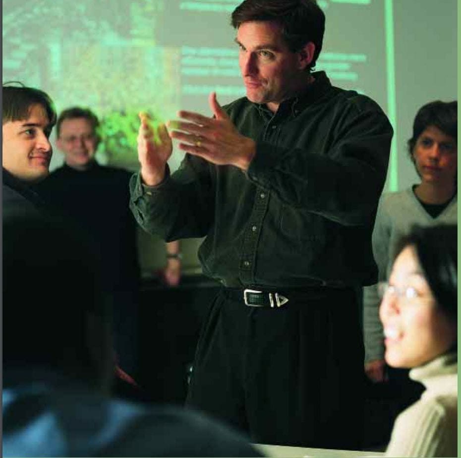 Peter Fader, Associate Professor, stands and does hand motions to explain a concept to students