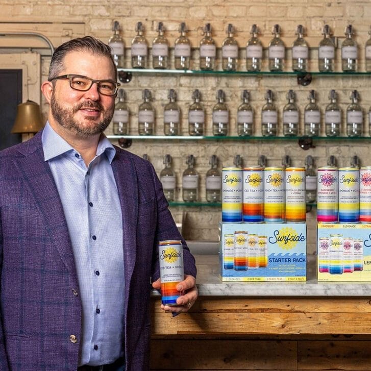 Clement Pappas stands in front of a bar stocked with Stateside and Surfside beverages.