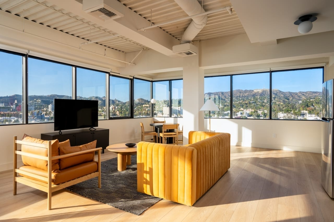 Living room with a yellow couch, TV, and table
