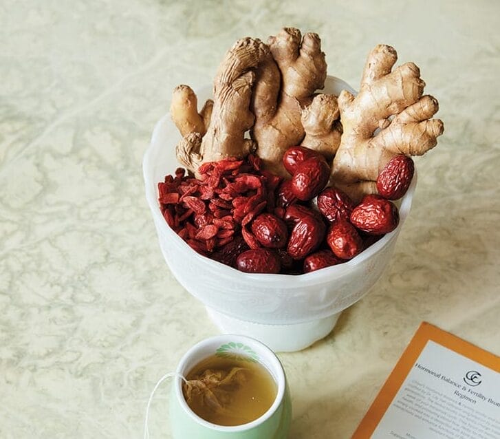 Ginger and berries in a dish on a table.