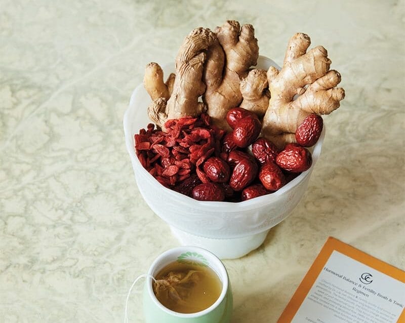 Ginger and berries in a dish on a table.