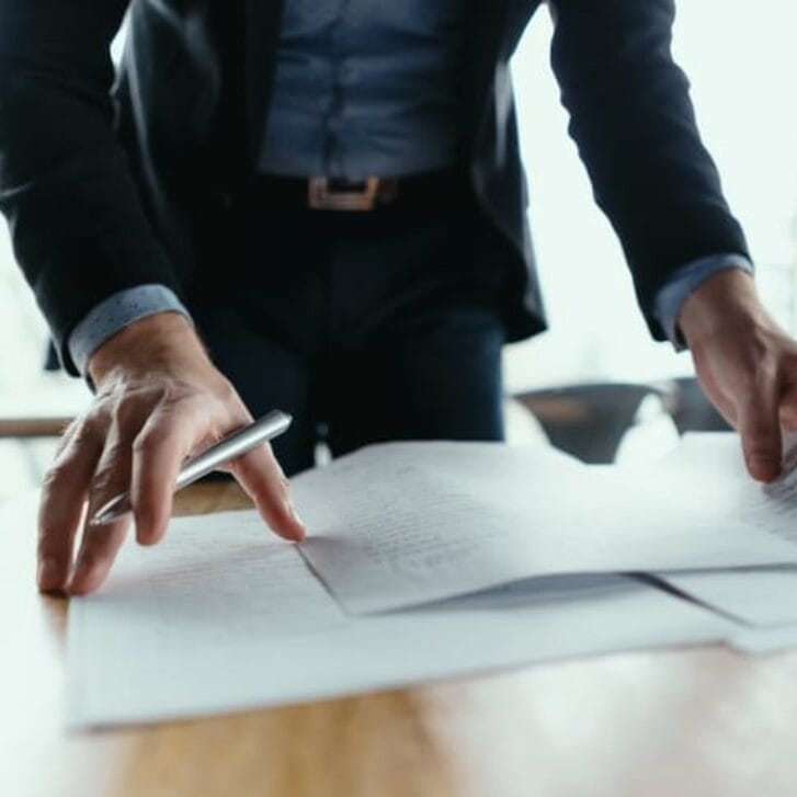 Businessman signing documents in office.