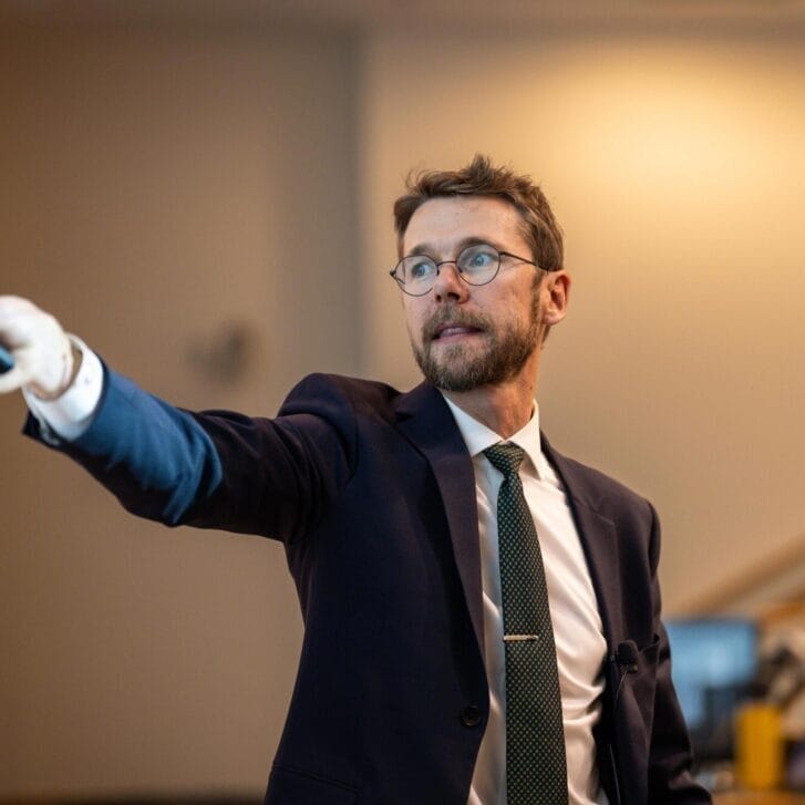 Ben Lockwood pointing to a screen in front of a classroom.