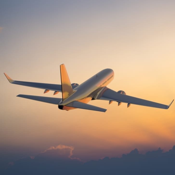 Passanger airplane flying above clouds in evening.