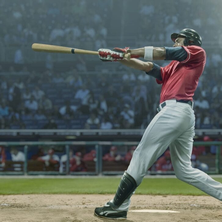 A baseball player hitting a baseball with a bat.