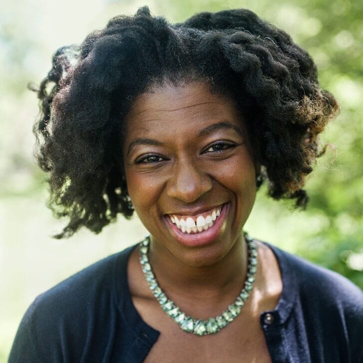 Portrait of a woman with a blue shirt and teal necklace.