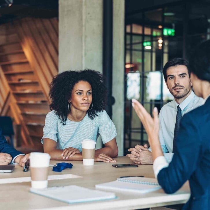 Colleagues sitting around a table during a meeting.