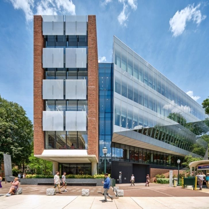 Exterior of the Academic Research Building during the day, with people milling about on the walkways in front of it.