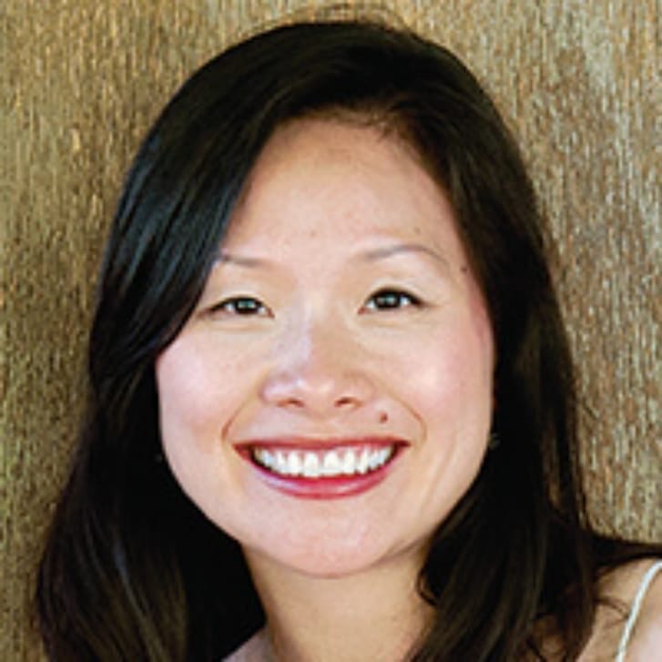 Smiling woman with straight black hair.