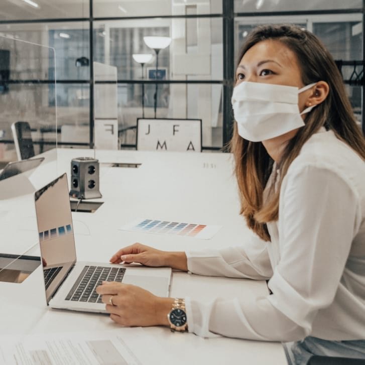 Employees in an office with glass partitions.