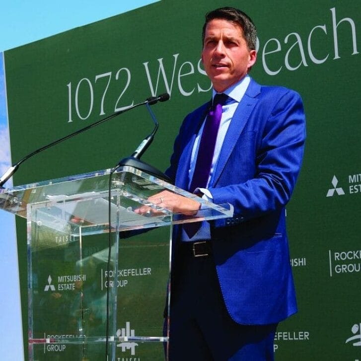 Dan Moore speaking at a podium during a building's groundbreaking