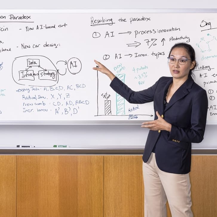 Wharton professor Lynn Wu standing in front of a whiteboard.