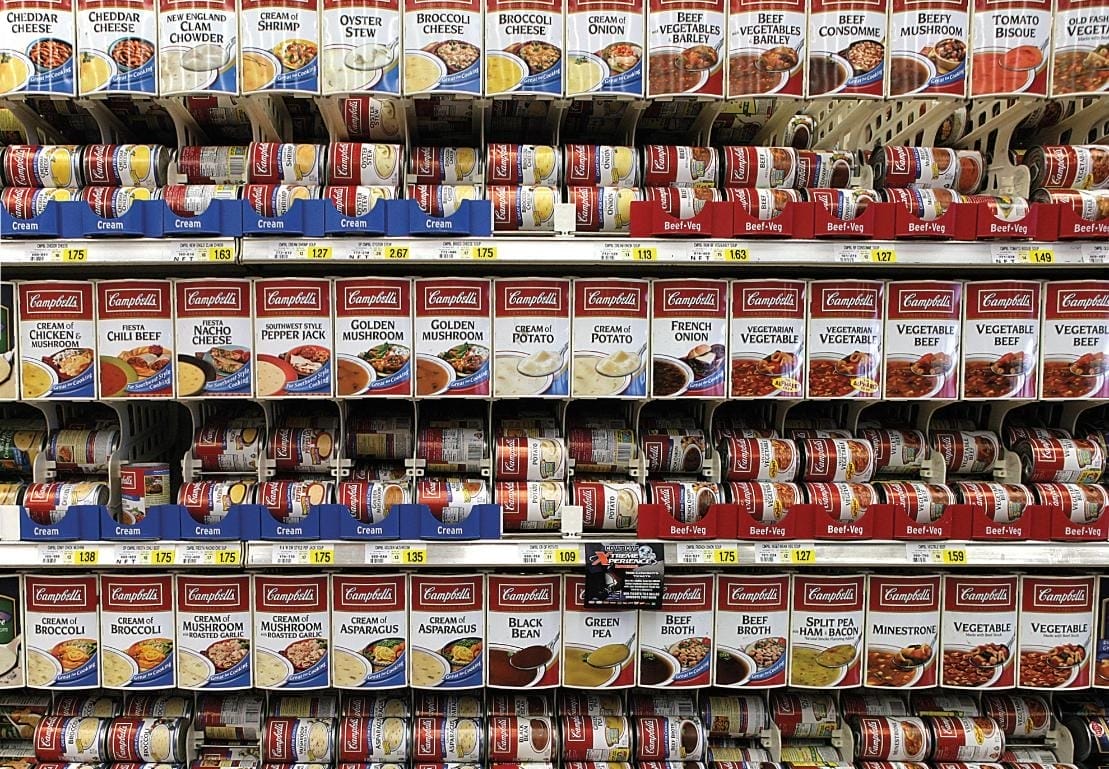 Campbell's soup cans on a store shelf.