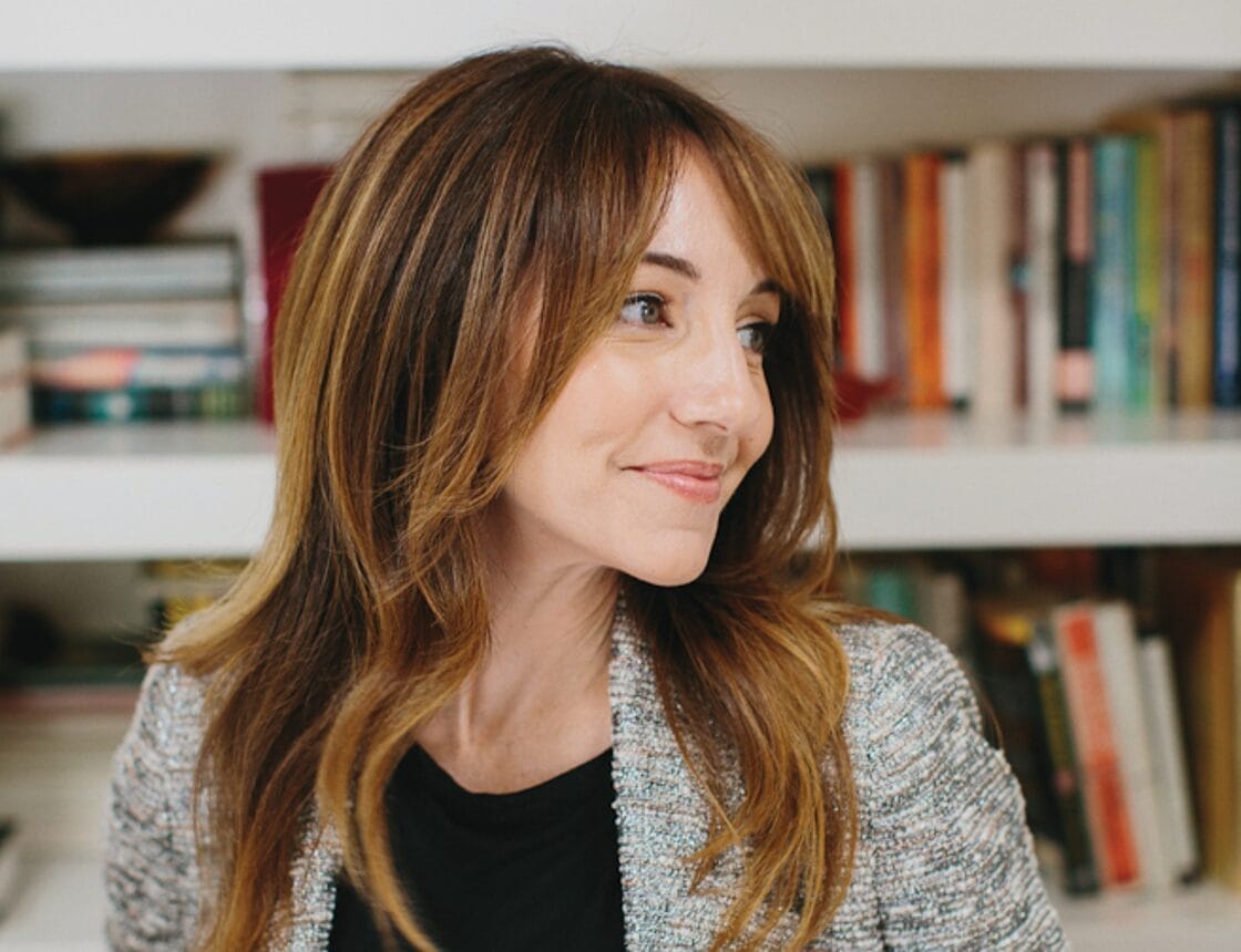 A woman with red hair looks to the side.