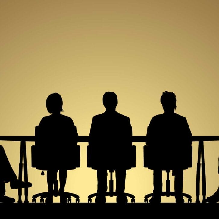Silhouette over a yellow background of a group of people at a board meeting