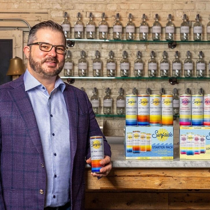 Clement Pappas stands in front of a bar stocked with Stateside and Surfside beverages.