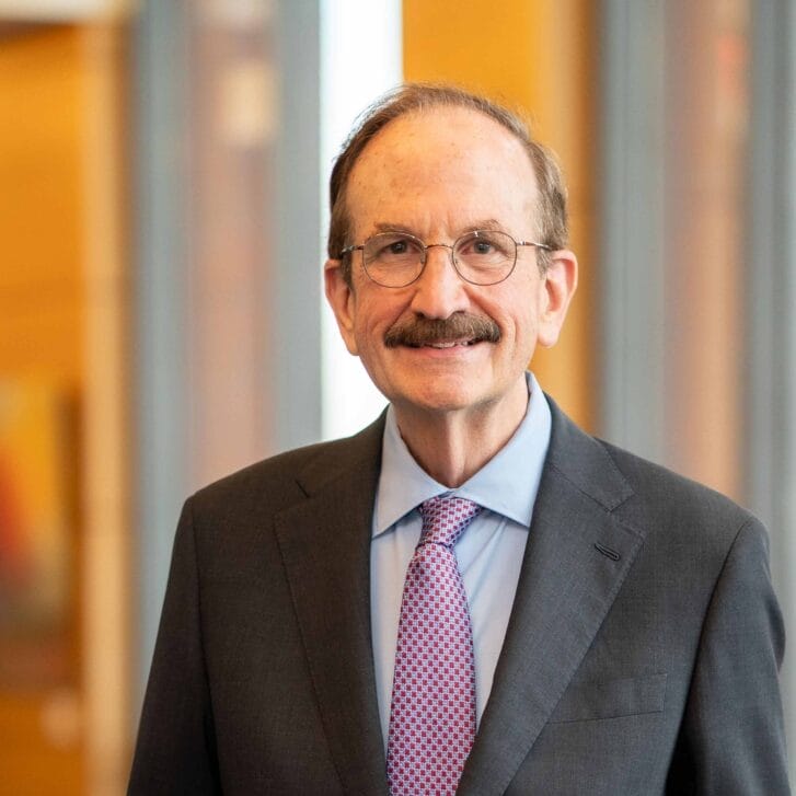 Dr. Bruce Jacobs standing in Huntsman Hall, wearing a suit and tie