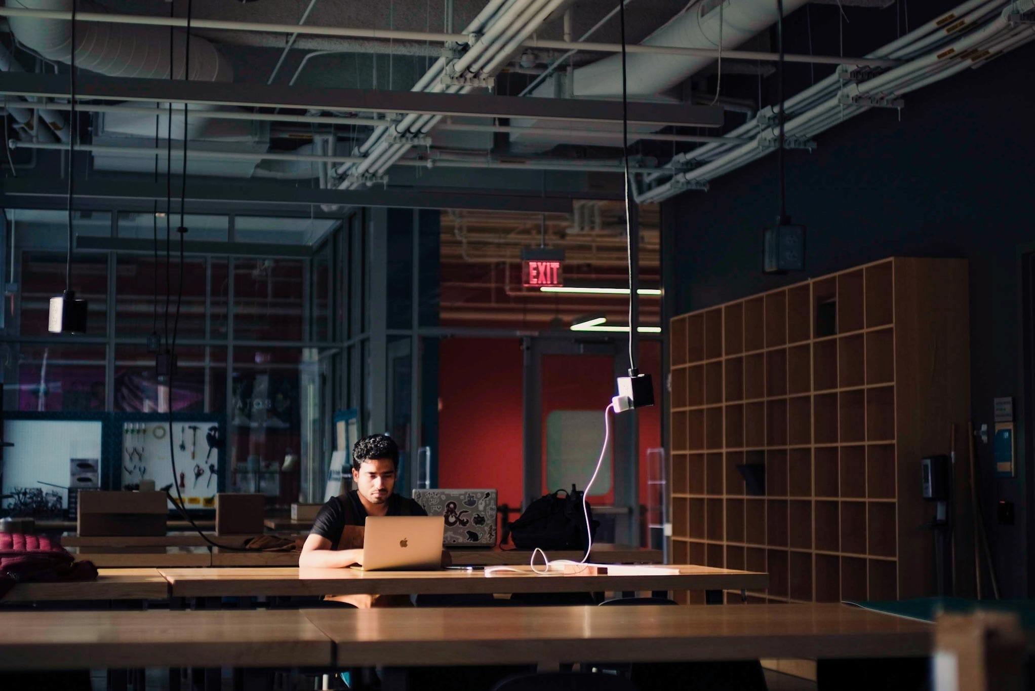 Young man sitting in front of a laptop in an empty laboratory room