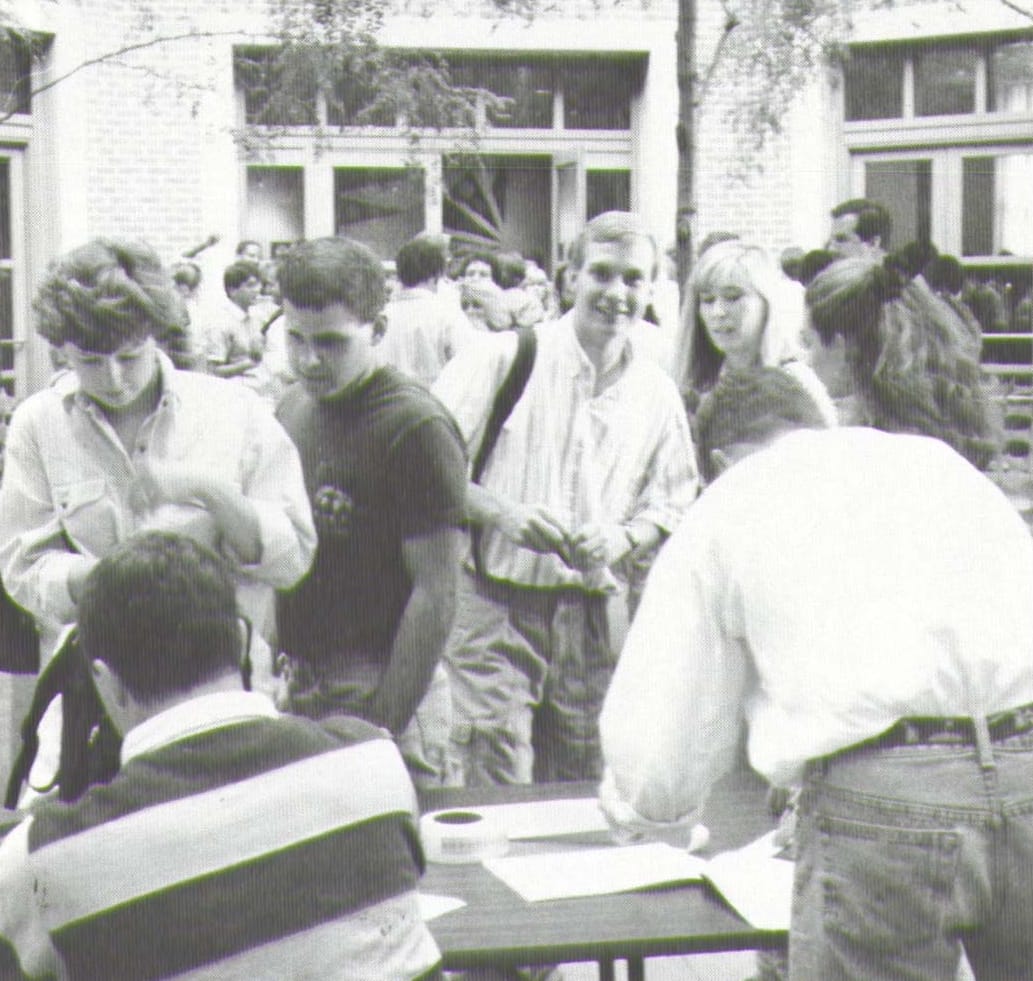 Black-and-white photo of students lined up outside for an event.